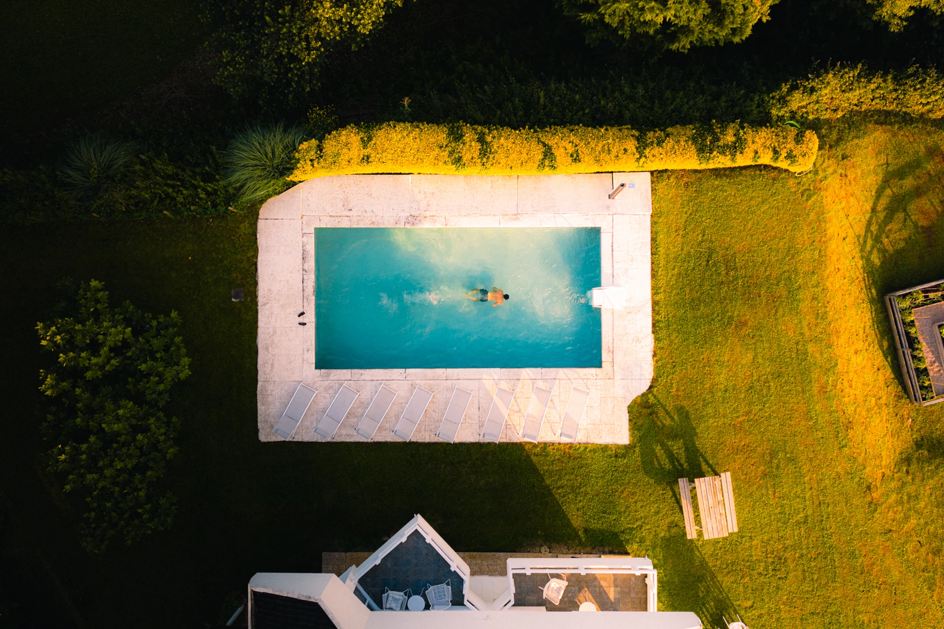 Casas con piscina y jardín de lujo en Wishome, terraza con tumbonas frente al agua turquesa